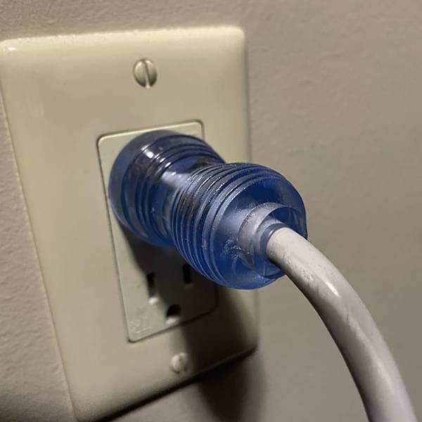 Photo of power cord plugged into wal receptacle